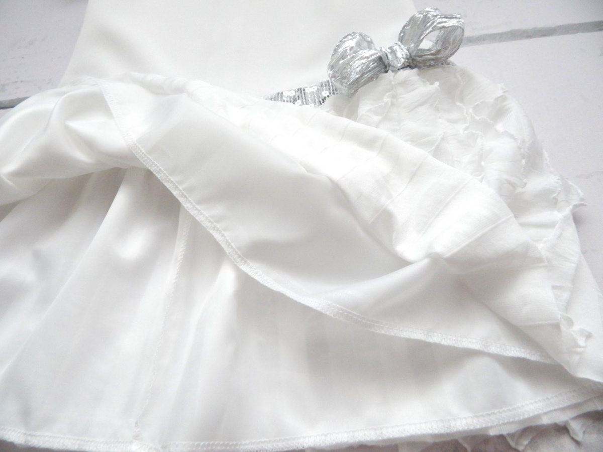 Elegancka sukienka ecrue z pionowymi falbankami i srebrnym paskiem Elegancka sukienka ecrue z pionowymi falbankami i srebrnym paskiem