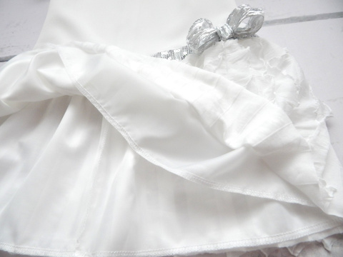 Elegancka sukienka ecrue z pionowymi falbankami i srebrnym paskiem Elegancka sukienka ecrue z pionowymi falbankami i srebrnym paskiem