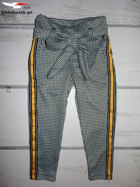 Elegantly sports a shepherd's Plaid pants with decorative tape and bow Elegantly sports a shepherd's Plaid pants with decorative tape and bow